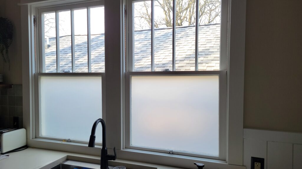 Kitchen windows with privacy frost glass in a rental home overlooking a bright exterior.